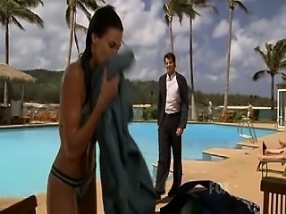 Brooke Burns getting out of a pool in a green bikini and