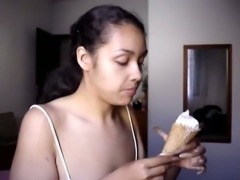 Kinky brunette with really long weird nails is eating ice cream