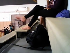 Teen school girl takes her shoes off after gym class
