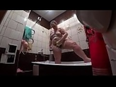 Behind the scenes, a hidden camera is spying on a fat porn model with a big ass in the bathroom.